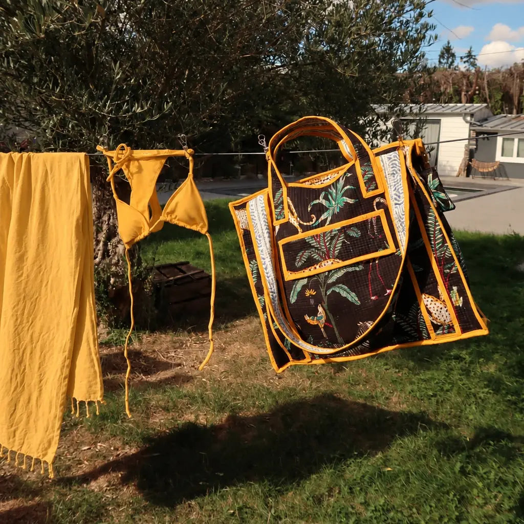 Sac KRUGER posé sur un fil à linge avec un maillot de bain et une serviette jaune assortis